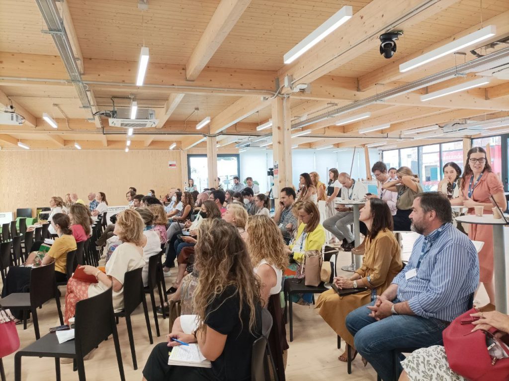 profesores sentados en una sala diáfana escuchando atentos a los ponentes a de la Jornada de Innovación Docente del 2022